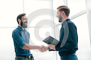 Meeting and shaking hands with business people in a bright office