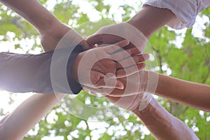 Meeting teamwork concept,Friendship,Group people with stack of hands showing unity on natural green background