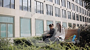 The meeting of two business women near business center. Meeting and discussion of the transaction two business women