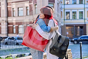 Meeting of two teenage girls friends, outdoor on the city street