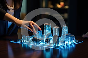 At a meeting, a woman explains the planning of a new neighborhood of the city on a model of the buildings illuminated with bluish