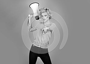 Megaphone and women. Portrait of pinup girl shouting. Young excited blonde fun woman pointing finger to the front. Idea