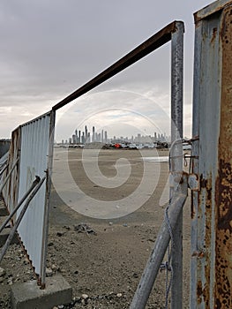 A megapolis outskirts revealling a jagged line of skyscrappers in the open gate of a construction zone photo