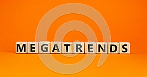 Megatrends symbol. The word megatrends on wooden cubes. Beautiful orange table, orange background. Business and megatrends concept