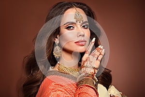 Mehendi. Portrait of beautiful indian girl in sari. Young hindu woman model with kundan golden jewelry set. Traditional Indian