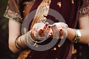 Mehndi covers hands of beautiful Indian woman