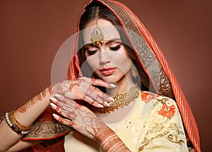 Mehndi. Portrait of beautiful indian girl in saree. Young hindu woman model with kundan golden jewelry set. Traditional Indian