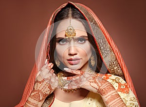 Mehndi. Portrait of beautiful indian girl in saree. Young hindu woman model with kundan golden jewelry set. Traditional Indian