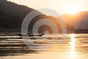 Mekong river, Laos and Thailand at Huay Xai. Traditional wooden boats at sunset