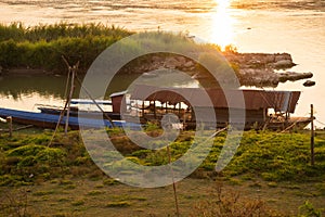 Mekong river, Laos and Thailand at Huay Xai. Traditional wooden boats at sunset