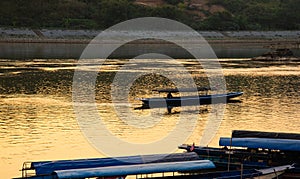 Mekong river, Laos and Thailand at Huay Xai. Traditional wooden boats at sunset