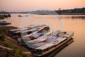 Mekong river, Laos and Thailand at Huay Xai. Traditional wooden boats at sunset