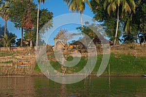 Mekong River Laos from the water showing riverbank activity and boats