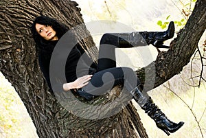 Melancholic girl sitting on the tree
