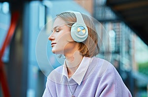 Melancholic lady student in earphones listens to music