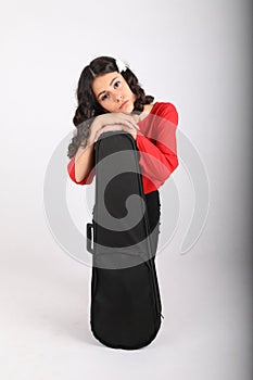 Melancholic teenage girl leaning on violin case