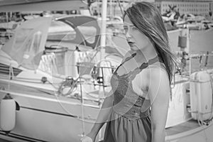 Melancholic woman in dress walking on marina