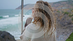 Melancholic woman looking ocean beauty standing gloomy coast closeup back view.