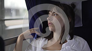 Melancholic woman traveling on the train with a sad look.