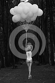 Melancholy. Lonely Woman with Balloons in Dark and Gloomy Forest