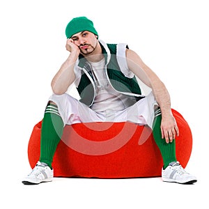 Melancholy man dressed like a gnome sitting on red