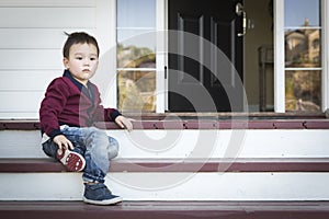 Melancholy Mixed Race Boy Sitting on Front Porch Steps