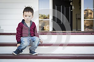 Melancholy Mixed Race Boy Sitting on Front Porch Steps