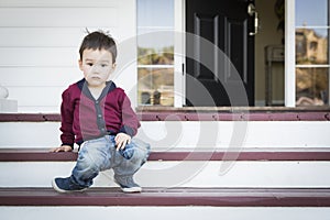 Melancholy Mixed Race Boy Sitting on Front Porch Steps