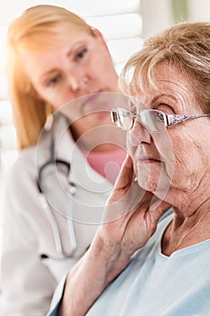 Worried Senior Adult Woman Being Consoled by Female Doctor or Nurse photo