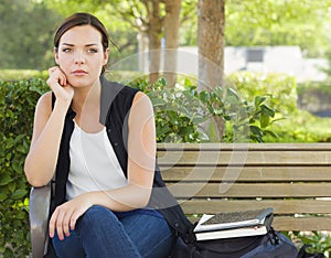 Melancholy Young Adult Woman Sitting on Bench Next photo