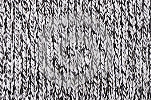 Melange woolen knitted fabric as background. Closeup of a grey knitted fabric texture as background.