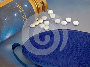 Melatonin supplements and sleep mask on the blue background