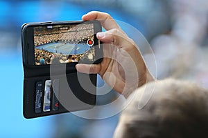 Unidentified spectator uses his cell phone to take images during tennis match at 2019 Australian Open in Melbourne Park