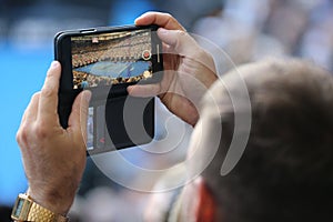 Unidentified spectator uses his cell phone to take images during tennis match at 2019 Australian Open in Melbourne Park