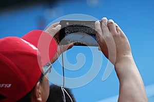 Unidentified spectator uses his cell phone to take images during tennis match at 2019 Australian Open in Melbourne Park