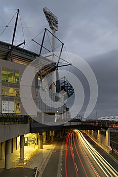 MELBOURNE, AUSTRALIA - 15 November 2019: Car light trail outside the Melbourne Cricket Ground with a grey sky.