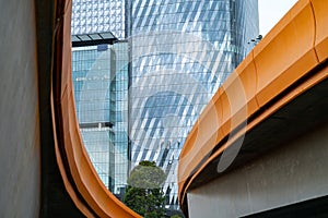 Melbourne Buildings through the curving and converging orange sides of Charles Grimes Bridge across Yarra River