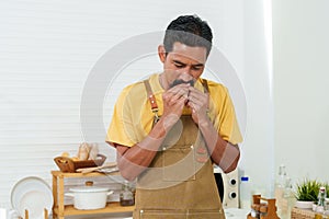 A melee chef is removing a bandage. A male chef was injured in a knife accident. The chef uses plaster to cover the wound on the