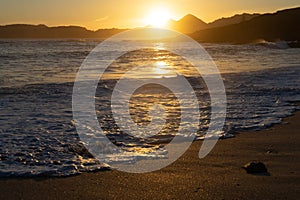 Melide beach surrounded by a pine forest in Home Cape natural zone at sunset in Rias Baixas. Pontevedra, Galicia, Spain