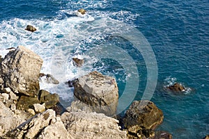 MELLIEHA, MALTA - 01 JAN, 2020: A man sitting on a rock near the ocean on the island of Malta during calm sea