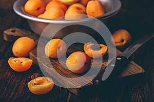 Mellow apricots with knife over cutting board