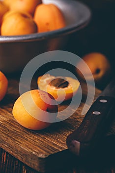 Mellow apricots with knife over cutting board