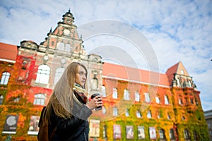 Mellow autumn. The lovely girl student has coffee.