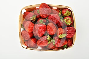 Mellow strawberries in wooden basket isolated on white