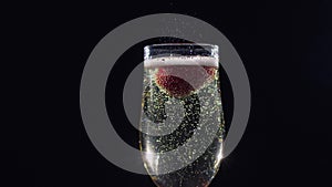 Mellow strawberry in glass with champagne sparkling wine. Slow motion