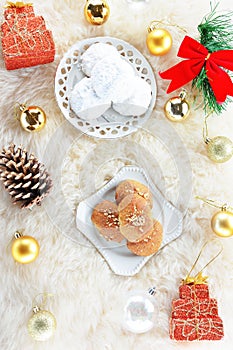 Melomakarona and kourabiedes ,traditional greek Christmas desserts on sheepskin carpet