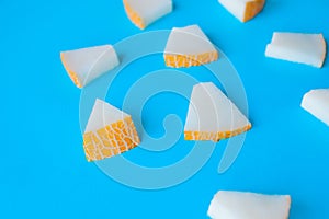 Melon cut into small pieces on a blue background, fresh fruit for snacks,