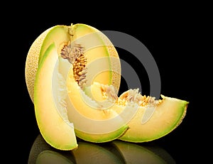 Melon galia notched with slices isolated black in studio photo