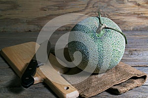 Melon and knife on cutting board