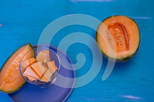 Melon pieces, on white table with blue plate
